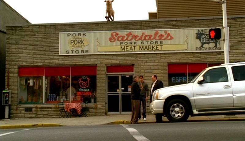 Many a shady deal took place outside Satriale's Pork Store & Meat Market. Tony Soprano (played by James Gandolfini) is shown at right, standing alongside his Cadillac Escalade. Photo provided by RR Auction. All rights reserved by copyright holder