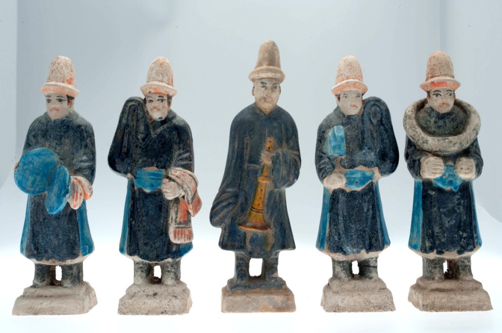 A group of Ming dynasty earthenware figures including a musician and traders. Photo Paul Burnett
